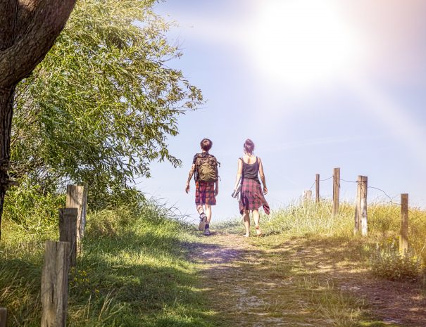 two teenager walking a path at noon